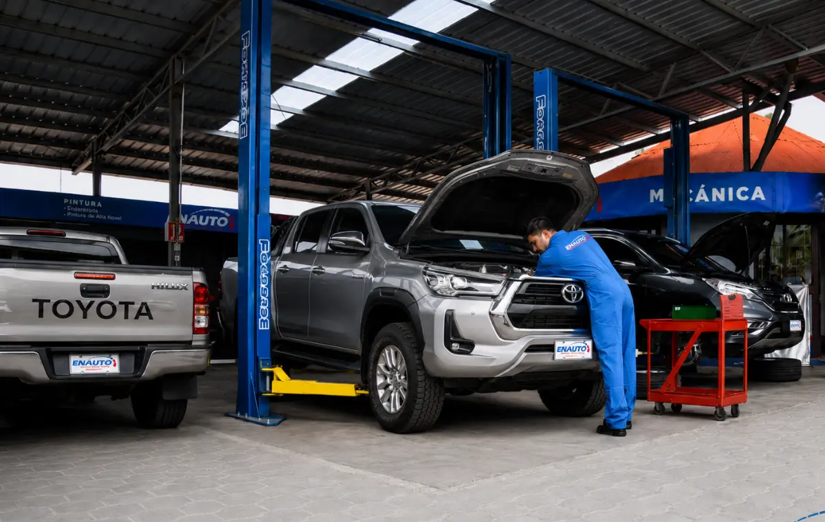 Técnico de ENAUTO trabajando en una Hilux en el elevador